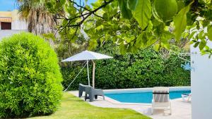 a pool with a table and an umbrella and chairs at Strip - Private Pool - 12 Guests - Albufeira in Albufeira