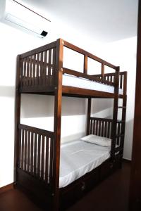 a wooden bunk bed with a white mattress at Back Packers Cochin Villa in Cochin