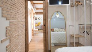 een slaapkamer met een bakstenen muur en een spiegel bij Apartamento ruh sara by Toledo AP in Toledo