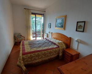 a bedroom with a bed and a door to a balcony at Antico Borgo I Cancelli in Palazzuolo sul Senio