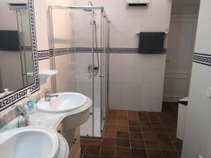 uma casa de banho com uma cabina de duche em vidro e um lavatório. em toni's apartament Menorca em Cala'n Bosch