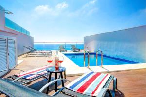 a patio with a pool and a table with glasses of wine at Villa Claraboya Sea View by Villa Plus in Torrox Costa