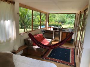 a hammock in the middle of a room with a couch at Cobijo in La Vega