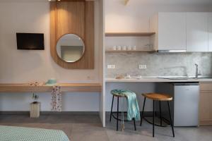 a kitchen with a sink and a counter with stools at Asteras Hotel in Sarti