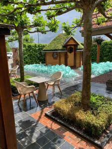 a patio with a table and chairs and a gazebo at B&B De Rentmeesterhoeve in Reningelst