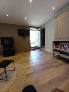 a living room with a wooden floor and a television at moulin de la chevanne in Laissey