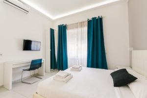 sypialnia z białym łóżkiem i niebieskimi zasłonami w obiekcie Appartamento 21 w Mediolanie