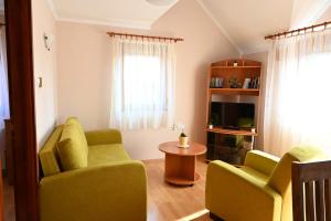 a living room with two chairs and a table at Liszkai Apartman in Gyula