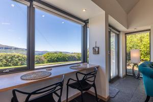 ein Heimbüro mit einem Schreibtisch und einem großen Fenster in der Unterkunft The Byre in Stein