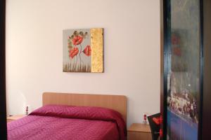 1 dormitorio con 1 cama y una pintura en la pared en Apartments Cabianchi, en Orta San Giulio