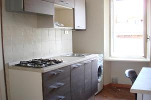a kitchen with a stove and a washing machine at Apartments Cabianchi in Orta San Giulio