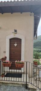 a garage door with two flower pots on a fence at Casavacanza al castello 2 in Villetta Barrea