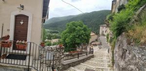 a set of stairs leading up to a building with mountains in the background at Casavacanza al castello 2 in Villetta Barrea