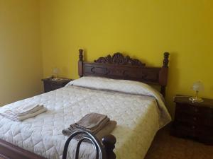 a bedroom with a bed with white sheets and two night stands at Casa Verde in Monticchio