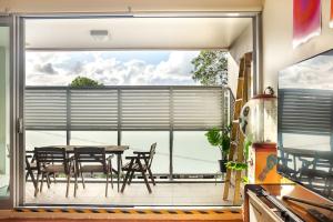 a patio with a table and chairs and a large window at Sprawling Modern City Pad Opposite Enmore Theatre in Sydney