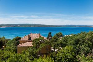 a house on a hill with the ocean in the background at Apartment Beta in Crikvenica