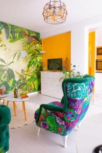 sala de estar con silla colorida y TV en Apartman GREEN en Brčko