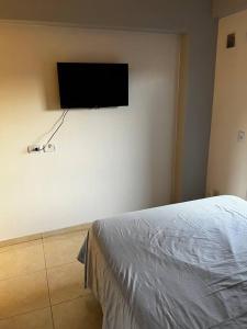 a bedroom with a flat screen tv on the wall at Departamento en San Miguel de Tucumán in San Miguel de Tucumán