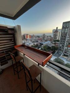 einen Balkon mit einer Bar mit Stühlen und Stadtblick in der Unterkunft Departamento en San Miguel de Tucumán in San Miguel de Tucumán