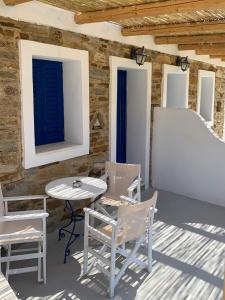 a patio with a table and chairs and a wall at Spiti Apartment in Mylopotas