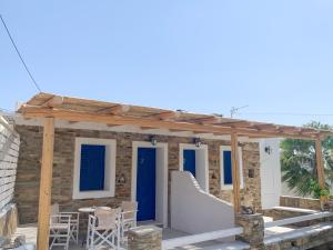 a house with blue doors and a table and chairs at Spiti Apartment in Mylopotas