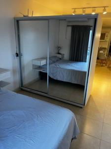 Schlafzimmer mit einer großen Glaswand und einem Bett in der Unterkunft Departamento en San Miguel de Tucumán in San Miguel de Tucumán