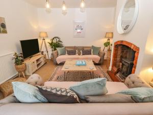 a living room with couches and a fireplace at Old Rectory Cottage in Lincoln