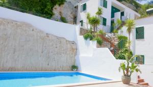 a villa with a swimming pool and stairs at Es Cucó in Cala Galdana