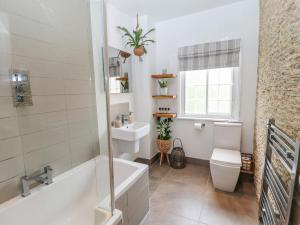 a bathroom with a tub and a toilet and a sink at Old Rectory Cottage in Lincoln +35 photos
