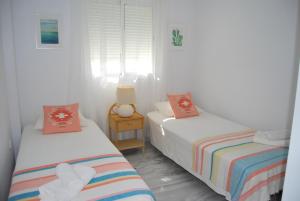 2 łóżka w pokoju z białymi ścianami w obiekcie AP261 - Pernille w mieście Nerja