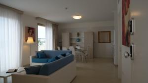 a living room with a blue couch and a table at La Corte di Leuca Residence in Leuca