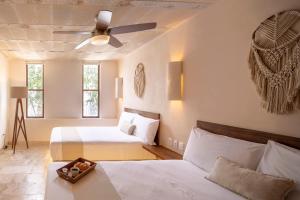 a bedroom with two beds and a ceiling fan at Kiki Tulum in Tulum +42 photos