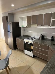 a kitchen with a stove and a refrigerator at Departamento en San Miguel de Tucumán in San Miguel de Tucumán