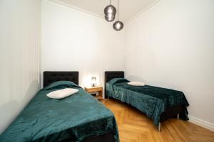 Dos camas en una habitación con sábanas verdes. en Suur-Sepa apartement, en Pärnu