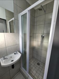un baño con ducha y lavabo en Grace Villas 8, en East London