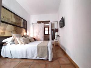 1 dormitorio con 1 cama blanca y TV en Casa Silca en Marbella