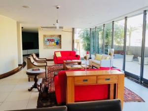 a living room with red furniture and large windows at Jumpinbed - Leblon Flat Service - Sala e quarto com varanda e vista do Mar. in Rio de Janeiro
