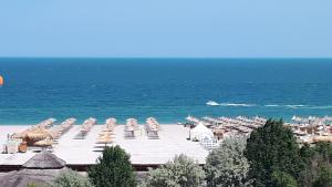 a beach with a bunch of umbrellas and the ocean at DreamView Mamaia SummerApt in Mamaia