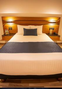 Cette chambre comprend un grand lit blanc. dans l'établissement Hotel Boutique Maria, à Morelia