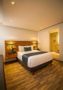 - une chambre avec un grand lit et une salle de bains dans l'établissement Hotel Boutique Maria, à Morelia
