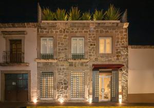 an old stone building with windows and lights on it at Hotel Boutique Maria in Morelia