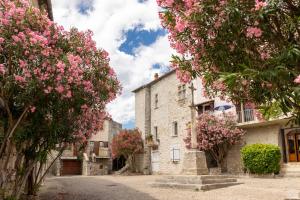 een straat in een dorp met roze bloemen bij Camping RCN La Bastide en Ardèche in Sampzon
