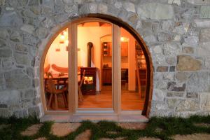 an arched window in a stone building with a table and chair at Granaries Pear & Walnut in Tolmin