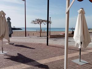 un gruppo di ombrelloni seduti su un marciapiede vicino alla spiaggia di ALOJAMIENTO PLAYA CHICA, LOS POZOS HABITACIONES a Puerto del Rosario