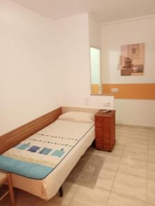 Dormitorio pequeño con cama y mesa en ALOJAMIENTO PLAYA CHICA, LOS POZOS HABITACIONES en Puerto del Rosario