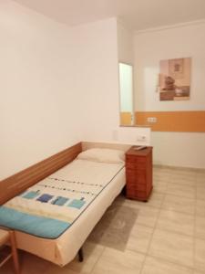 a small bedroom with a bed and a table at ALOJAMIENTO PLAYA CHICA, LOS POZOS HABITACIONES in Puerto del Rosario