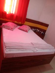 ein Bett mit weißer Bettwäsche und rosa Kissen in der Unterkunft Hotel Lalique in São Paulo