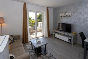 a living room with a couch and a television at Apartments Vicin in Brela