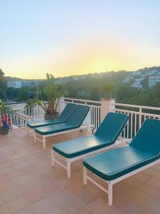 a row of blue lounge chairs on a balcony at Es Cucó in Cala Galdana