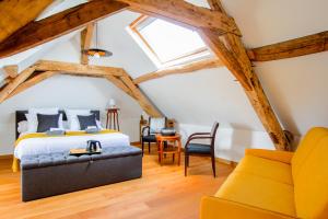 a bedroom with a king sized bed and a chair at La Bohal' Loire in La Bohalle